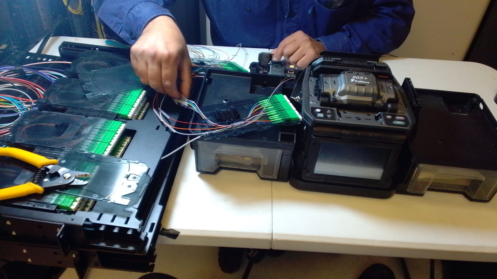 Trabajo de empalme de fibra óptica con equipo de fusión y bandejas de distribución